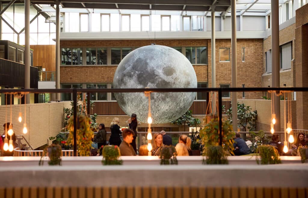 A huge moon decoration appearing to be floating in the middle of a restaurant